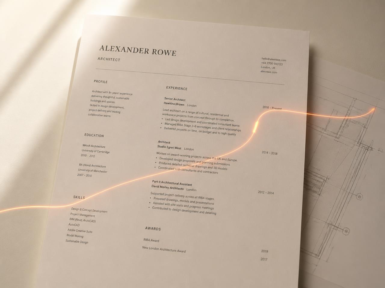 A printed CV on cream paper traced by a thin line of orange light next to an architectural blueprint